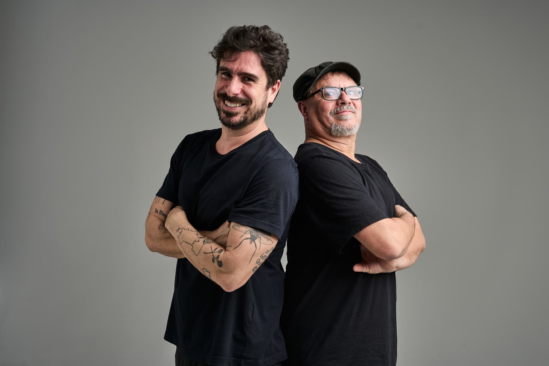 Os professores e autores do dicionário, de braços cruzados, costas com costas